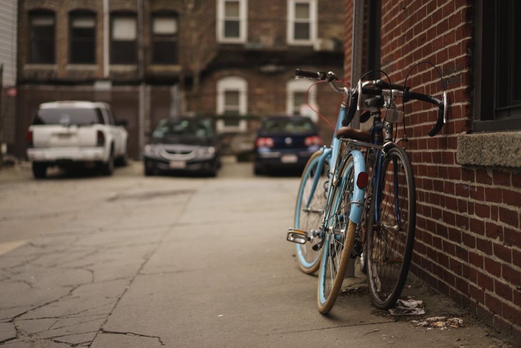 Bicycles leaning against a brick building on a back street